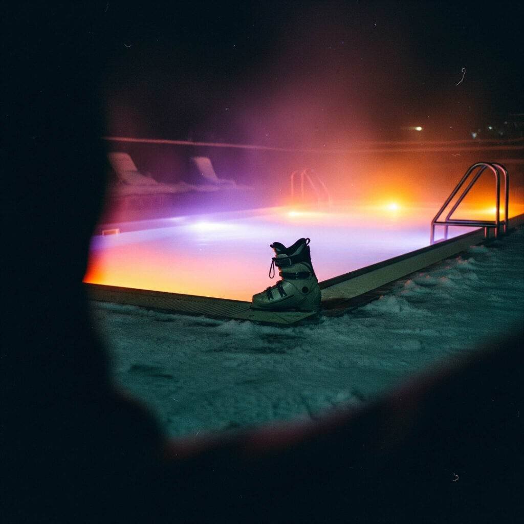 Vintage photo of a glowing pool at night with a single ski boot.