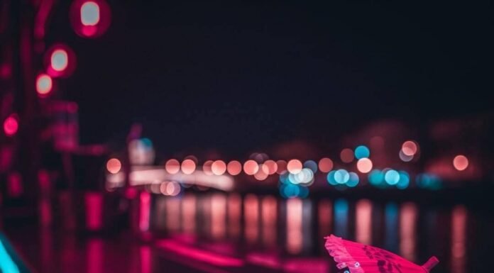 Lyon Night Bars vs Paris: Which City Wins on Drinks? Neon-lit bar, spilled drink, oversized umbrella, blurred river background.