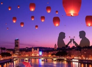 Top Rooftop Bars in Lyon with Stunning City Views Lyon cityscape at dusk with cocktail and lanterns.