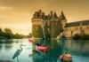 Loire Kayaking Adventure: Castles, Wildlife & Fun Kayaker, heron, and picnic basket with a castle in the background.