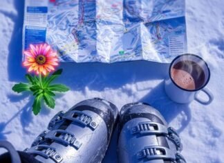 The Ultimate Skiing Alps Guide for Beginners Scratched ski boots, crumpled map, hot cocoa, and an alpine flower in snow.