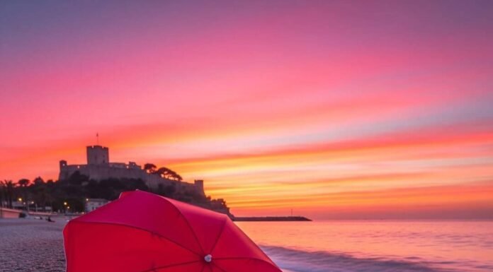 Sunsets, Beaches & Castles: Côte d’Azur’s Top Sights Red parasol on a pebbly beach at sunset.